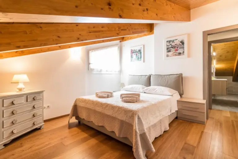 camera matrimoniale in mansarda con soffitto in legno di Apartment Belvedere 5 a Lenno