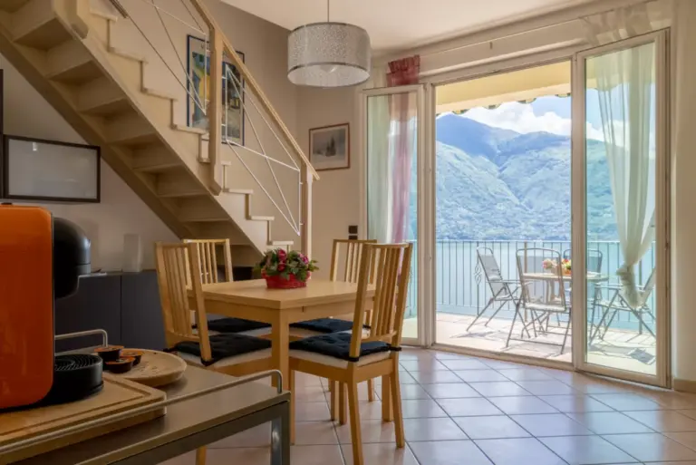 Zona pranzo di Apartment Daniela con scala interna e porta-finestra sulla terrazza vista lago