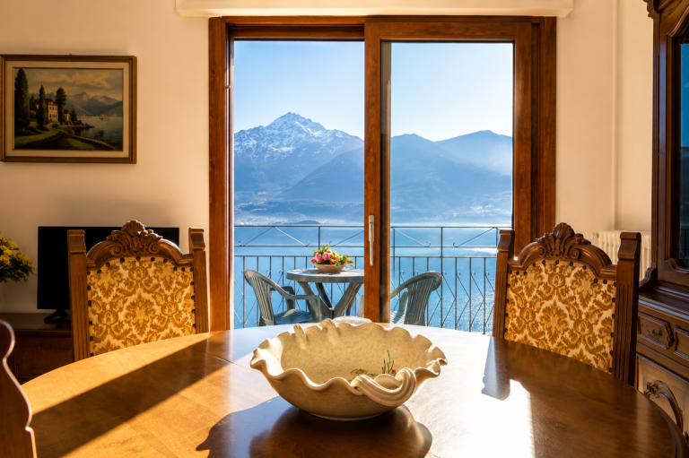 Sala da pranzo di Alex 1 a Domaso con tavolo affacciato sul panorama del lago e delle montagne