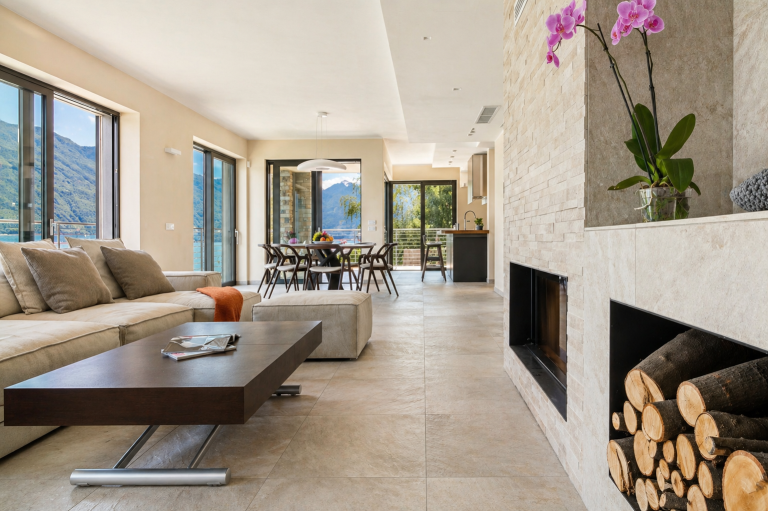 Soggiorno open space di Villa del Sasso con camino, zona pranzo e vista sul Lago di Como