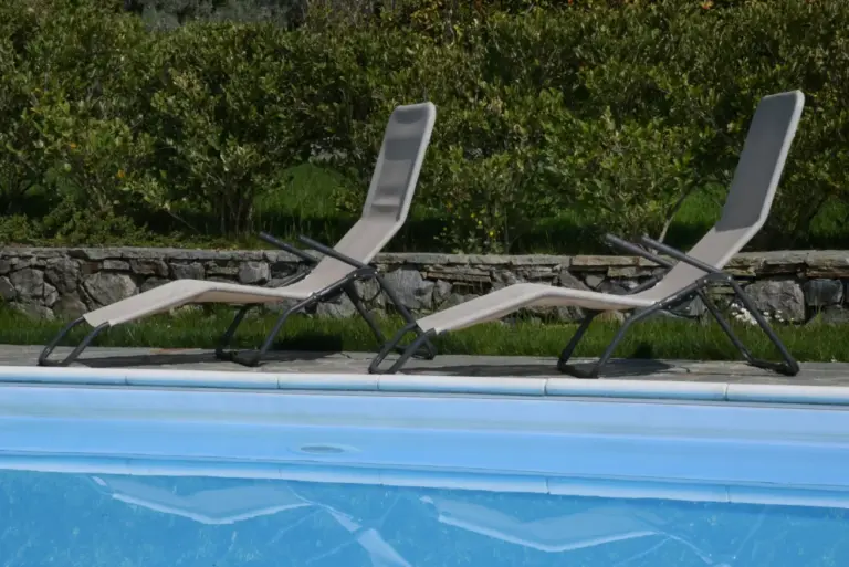 Lettini prendisole a bordo della piscina condivisa del Residence Gli Ulivi a Tremezzina