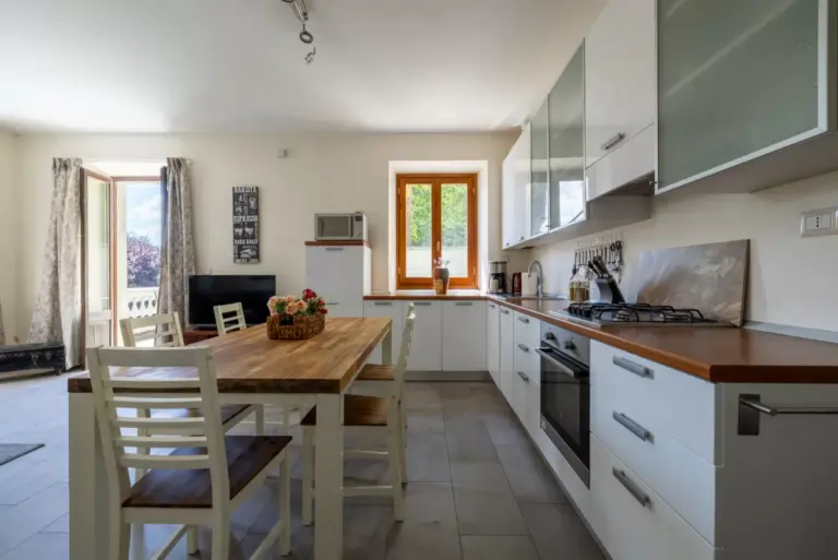 Cucina attrezzata con piano in legno e angolo pranzo dell'Appartamento Katia a Menaggio