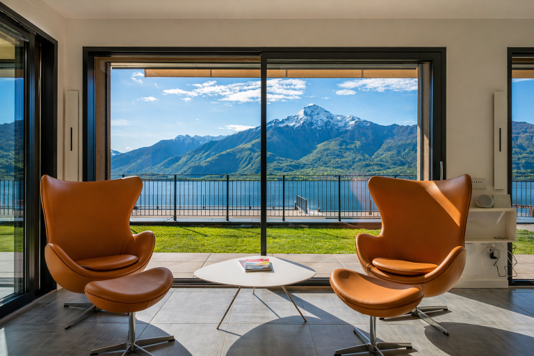 Due poltrone di design nel soggiorno dell'Apartment Lana con vista panoramica sul Lago di Como