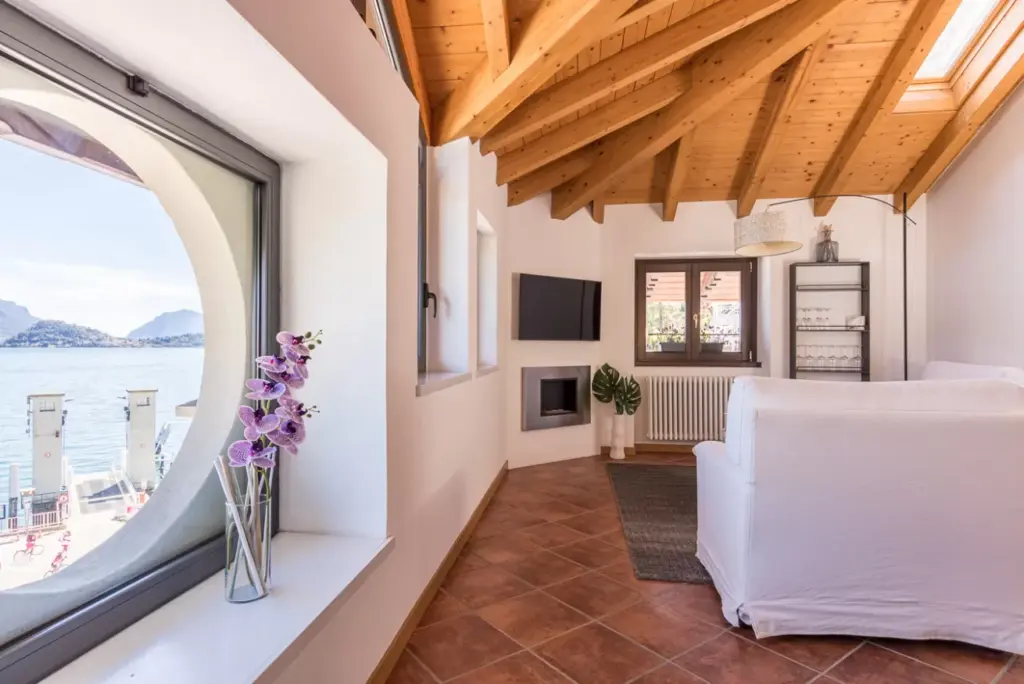 Soggiorno in mansarda di Tamara Suite a Menaggio con oblò vista Lago di Como
